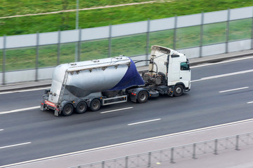 Wall Mural - Truck with a trailer bulk cargo rides on the highway.