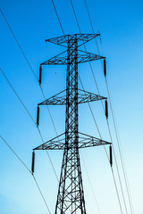 High voltage tower  and line cables, in blue sky background