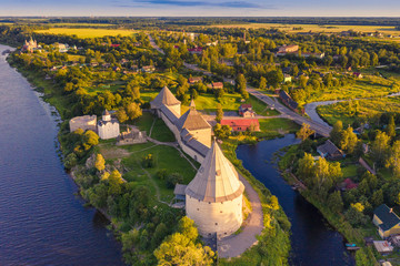 Top aerial view of Staraya Ladoga fortress on a sunny day, green fields and meadows in summer. Landscape with drone. Staraya Ladoga, Leningrad Region, Russia.