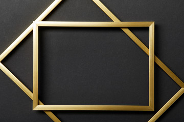 top view of empty golden frames on black background