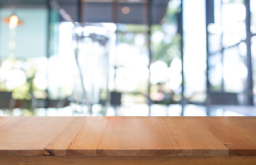 Wall Mural - wooden table with blurred of coffee's shop for abstract background