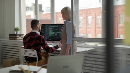 tracking left of caucasian businessman working at his workplace while his female colleague coming to
