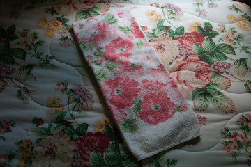 floral towel on floral bedspread
