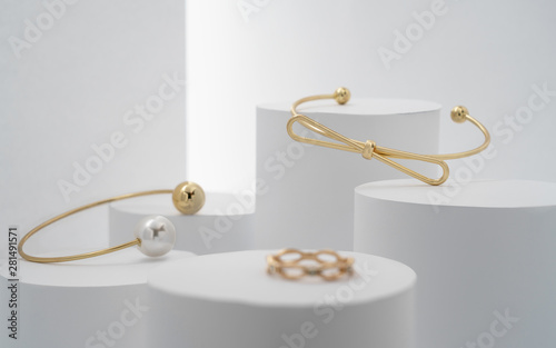 Fotografía Modern golden bracelets and ring on white cylinders setup
