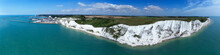 Aerial Panorama Of Port Of Dover With Ferry Ships Docked In Passengers Terminal And View Over White Cliffs, Coastal Countryside On A Sunny Summer Day, South East England .