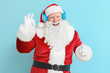 © Pixel-Shot - Portrait of Santa Claus listening to music on color background