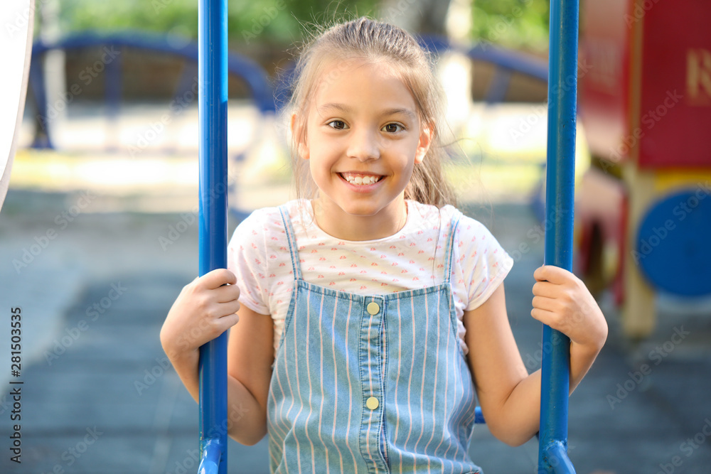 Cute little girl on swings in park