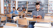 © JackF - Portrait of young bearded man sitting in public library and reading books