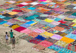 © Mint Images - High angle view of children walking in field beside colorful clothes
