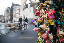 Man And Woman Riding Bicycle By Love Padlocks
