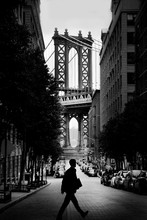 Man Walking On Street With Manhattan Bridge In Background