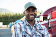 © Mint Images - Portrait of truck driver standing at truck stop