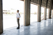 © Mint Images - Side view of architect standing at entrance in warehouse