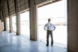 © Mint Images - Rear view of architect standing at entrance in warehouse