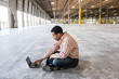 © Mint Images - Side view of architect working on laptop in warehouse