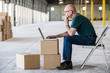 © Mint Images - Side view of architect working on laptop in warehouse