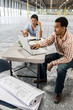 © Mint Images - Architects working at table in warehouse