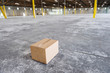 © Mint Images - Cardboard box in middle of empty warehouse
