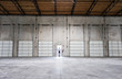 © Mint Images - Rear view of man standing at door of warehouse