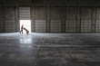 © Mint Images - Man pushing hand truck loaded with cardboard box in warehouse