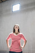 © Mint Images - Woman standing underneath light from window in warehouse