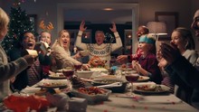 happy family christmas dinner party celebrating with crackers sharing homemade feast with friends enjoying evening of fun holiday celebration at home 4k footage