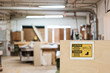 © Mint Images - Warning sign for safety gear regulations in workshop
