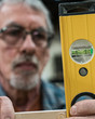 © Mint Images - Close up of carpenter measuring wood with spirit level
