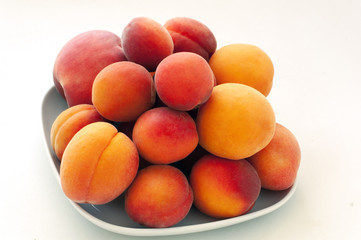 Isolated fresh juicy peaches fruits and ripe apricots isolated on white plate. Summer fruit concept. Close-up