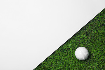 Poster - Golf ball and white paper on green artificial grass, top view with space for text