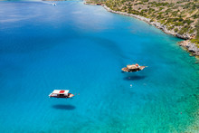 Aerial View Of Traditional Greek Boats Over A Crystal Clear, Warm Ocean On The Island Of Crete