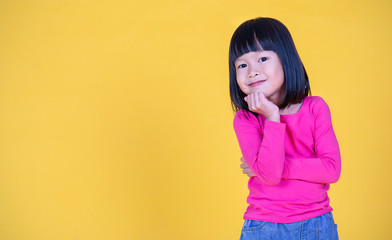 Wall Mural - Portrait of young happy little asian girl isolated on yellow background with copy space. Education for toddler or preschool, childhood lifestyle back to school concept