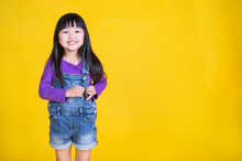 Portrait Of Young Happy Little Asian Girl In Uniform Isolated On Yellow Background With Copy Space. Education For Toddler Or Preschool, Childhood Lifestyle Back To School Concept