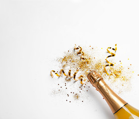 bottle of champagne with gold glitter, confetti and space for text on white background, top view. hi