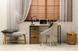 © New Africa - Comfortable workplace near window with horizontal wooden blinds
