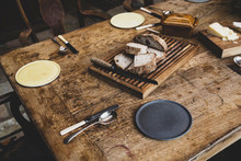 Plates, Cutlery And Bread On Wooden Table