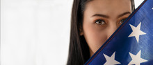 Portrait Of Woman Face Behind American Flag On Bright Background