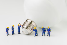Business Creative Idea, Sustainability Power Or Energy Generator Concept, Miniature People Figurine Engineer Worker Help Building Light Bulb On White Background