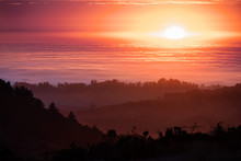 Brightly Colored Sunset In The Santa Cruz Mountains, Layered Hills And Valleys Visible In The Foreground And Sea Of Clouds In The Background; San Francisco Bay Area, California