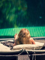 Wall Mural - Beautiful woman relaxing by poolside