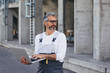 © cherryandbees - worker using laptop in front of grain silos outdoor