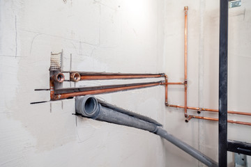 Wall Mural - Closeup many new sewer copper and plastic pipes, fittings on concrete wall. Concept installation, replacement of plumbing, repair of pipeline, professional master plumber, leakage pipe