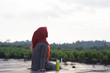 © SVRSLYIMAGES - portrait of hijab woman was sitting on the boardwalk in the sunshine of a beautiful mangrove garden while waiting