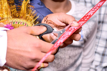 Wall Mural - Cutting Ribbon in Indian Wedding Ritual Welcome Ceremony