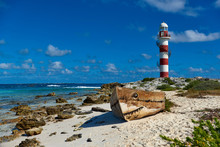 Old Boat On The Beach And Lighthouse