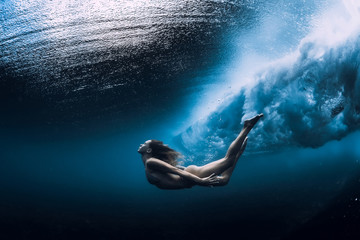 Wall Mural - Woman swim underwater with ocean wave.