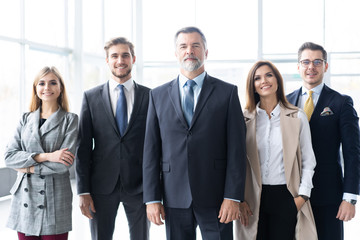 Happy business team with arms crossed at the office.