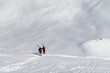 Two skiers with skis on his shoulder and off-piste slope
