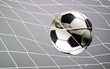 © suman - Scoring goal, Soccer ball in the net against gray background.