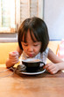 Leinwandbild Motiv Asian Little Chinese Girl drinking hot tea